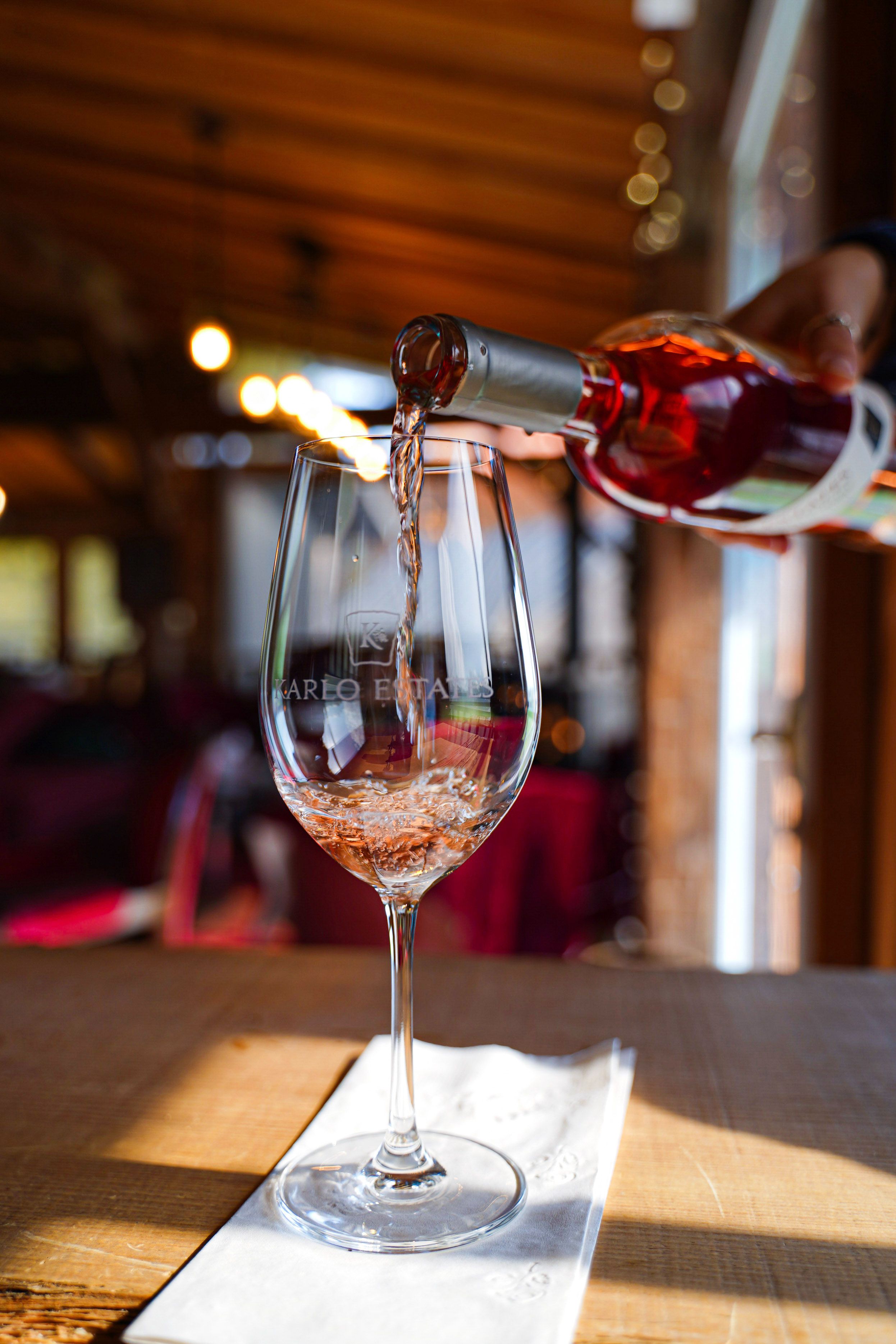 A glass of wine being poured in a luxurious cabin-style restaurant